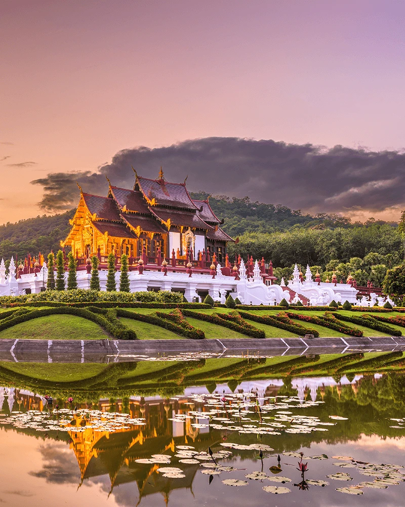 Royal Flora Ratchaphruek temple reflected in water at sunset, Chiang Mai